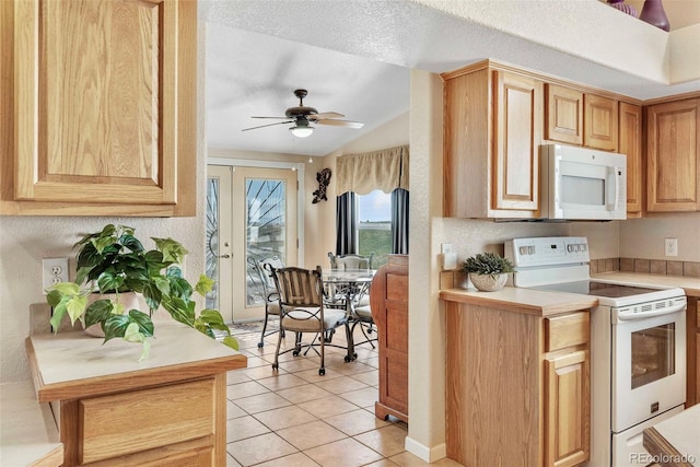 5129 S Tom Bay Rd, Bennett, CO 80102 - kitchen featuring a ceiling fan, light tile patterned floors, white appliances, vaulted ceiling, and light countertops