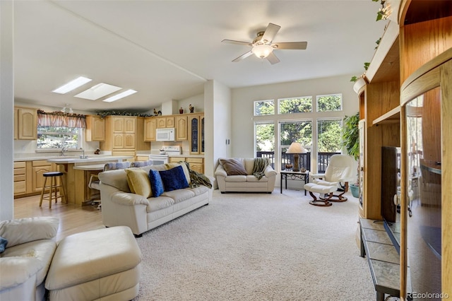 688 Tiara Rd, Lake George, CO 80827 - living room with lofted ceiling, a ceiling fan, a skylight, and light colored carpet