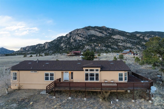 688 Tiara Rd, Lake George, CO 80827 - back of property featuring a deck with mountain view, stucco siding, and roof with shingles