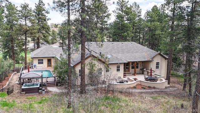back of house featuring a fire pit, a patio, stucco siding, and a shingled roof