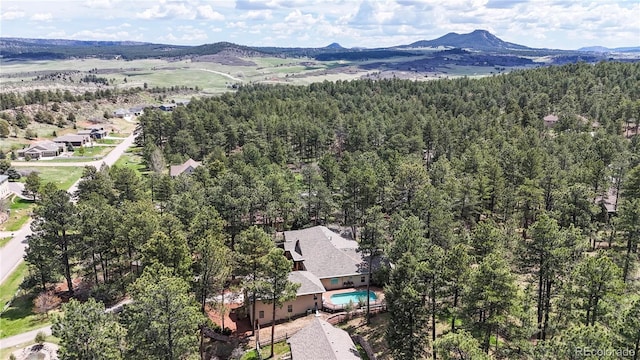 aerial view of a mountainous background and a heavily wooded area