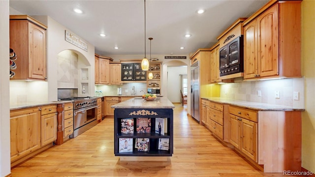 kitchen with open shelves, built in appliances, arched walkways, light wood-type flooring, and backsplash
