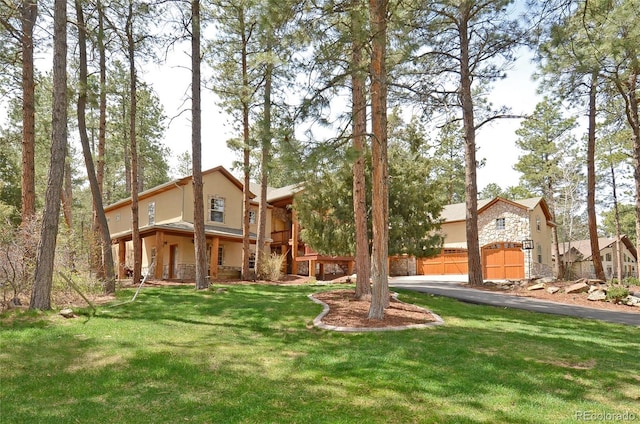 view of front of home with stone siding, stucco siding, and a front yard