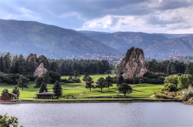 view of property's community featuring golf course view, a water and mountain view, and a lawn
