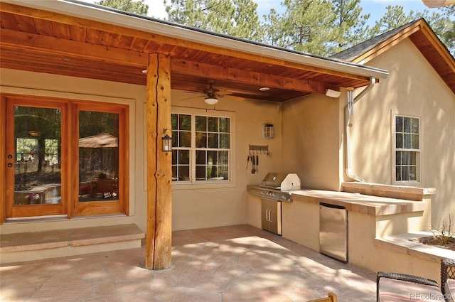view of patio / terrace featuring an outdoor kitchen, ceiling fan, and a grill