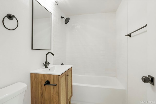 full bathroom featuring tiled shower / bath, vanity, and toilet