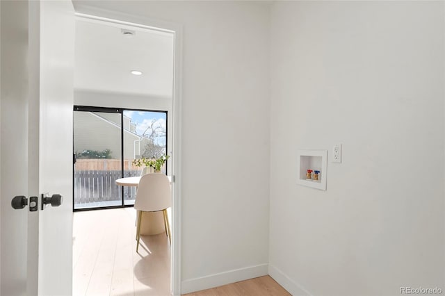 clothes washing area featuring washer hookup and light hardwood / wood-style flooring