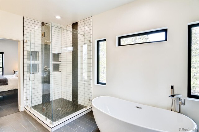 30298 San Isabel Rd, Buena Vista, CO 81211 - bathroom featuring a soaking tub, tile patterned flooring, ensuite bathroom, a stall shower, and plenty of natural light