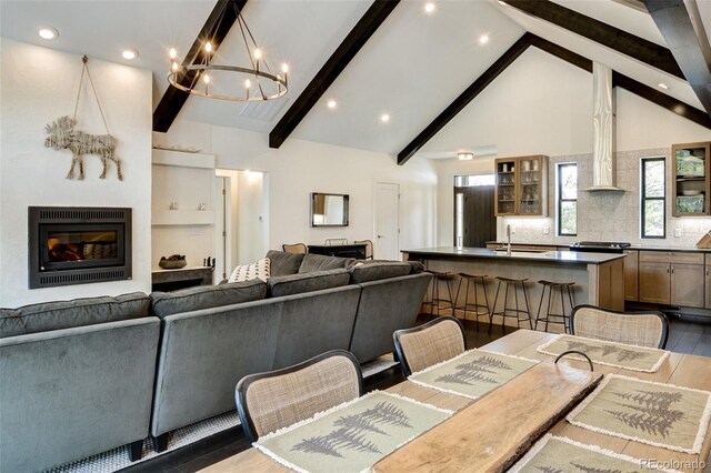 30298 San Isabel Rd, Buena Vista, CO 81211 - dining space featuring beam ceiling, a chandelier, recessed lighting, wood finished floors, and a glass covered fireplace