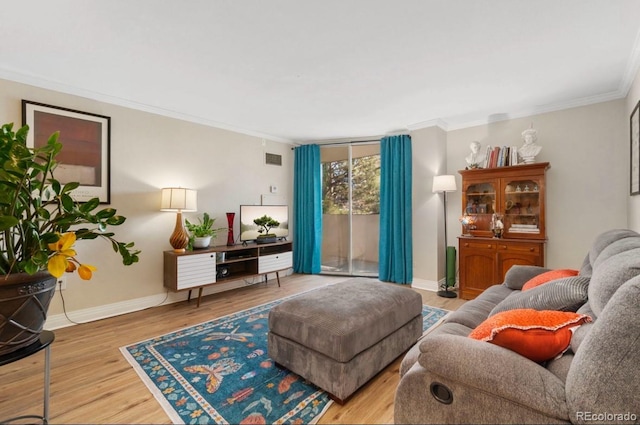 living room with baseboards, crown molding, and wood finished floors