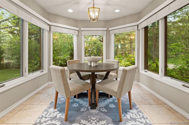 sunroom / solarium featuring tile patterned floors, baseboards, a chandelier, and recessed lighting