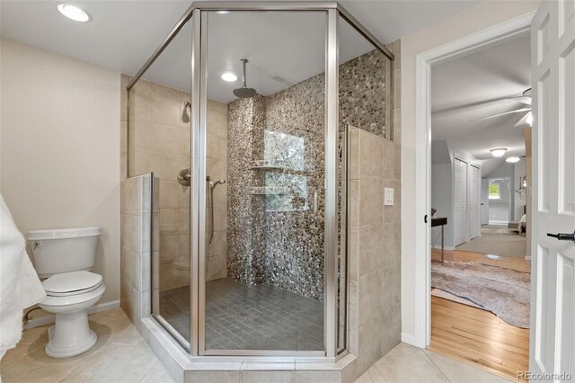 full bath with a shower stall, toilet, and tile patterned flooring