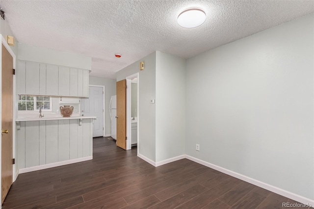 kitchen featuring white cabinets, dark wood-style floors, light countertops, and freestanding refrigerator