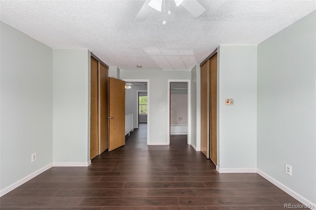 spare room featuring dark wood-type flooring, ceiling fan, and a textured ceiling