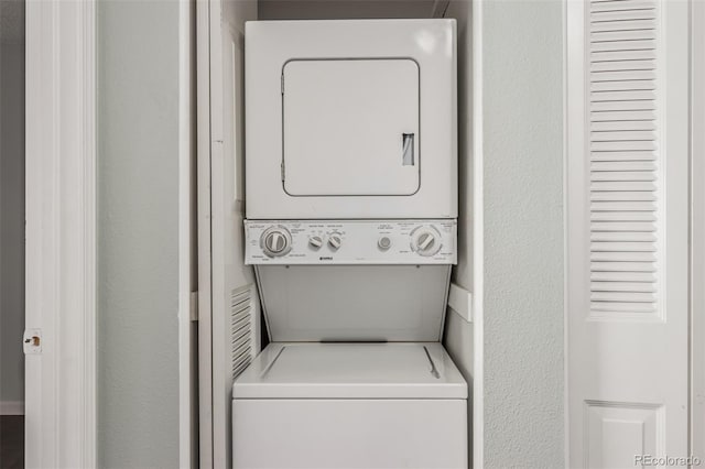 washroom featuring laundry area and stacked washer / drying machine