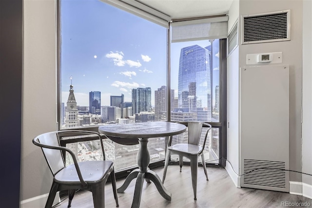 dining area featuring floor to ceiling windows, light hardwood / wood-style floors, and a wealth of natural light