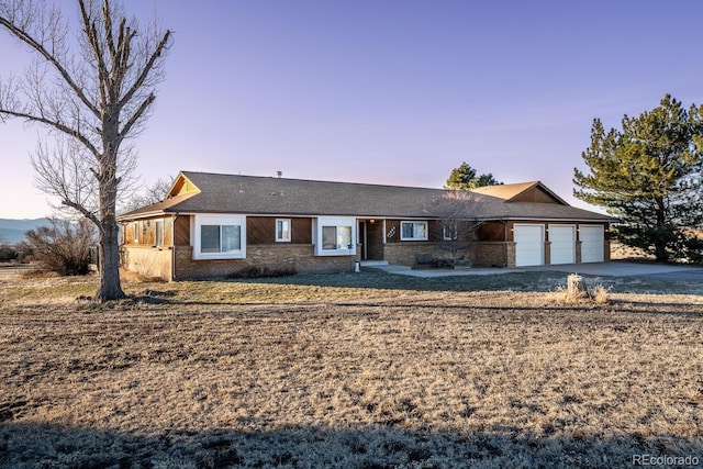 ranch-style home with brick siding, a garage, and driveway