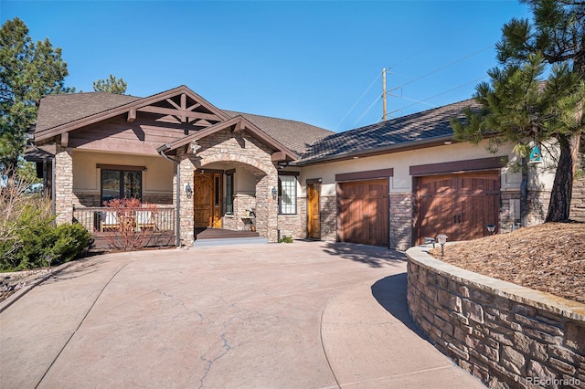 craftsman house featuring stone siding, a garage, driveway, and stucco siding