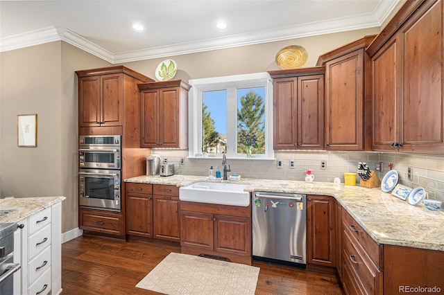 kitchen with dark wood-style floors, a sink, ornamental molding, and appliances with stainless steel finishes