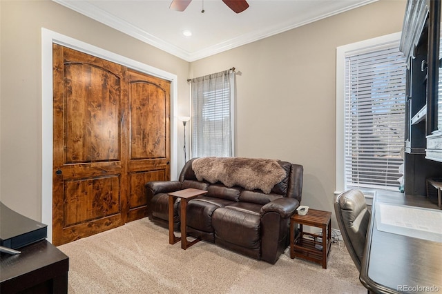 sitting room featuring ornamental molding, a ceiling fan, and light carpet