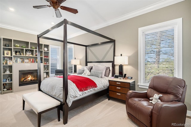 bedroom with ornamental molding, recessed lighting, light colored carpet, and a glass covered fireplace