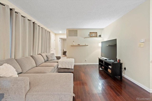 living room featuring a textured ceiling and dark hardwood / wood-style floors