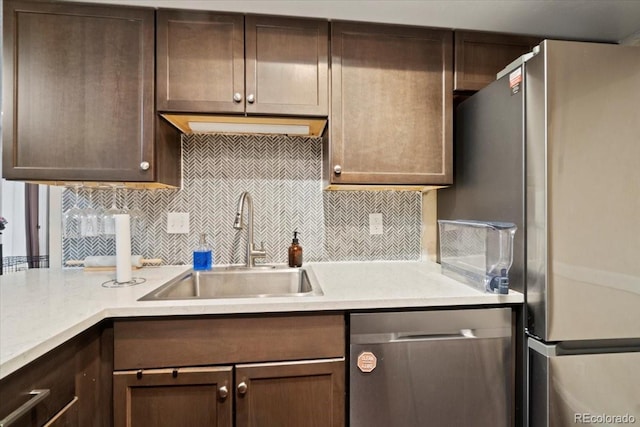 2306 S Troy St Unit A, Aurora, CO 80014 - kitchen featuring tasteful backsplash, a sink, dark brown cabinetry, light countertops, and appliances with stainless steel finishes