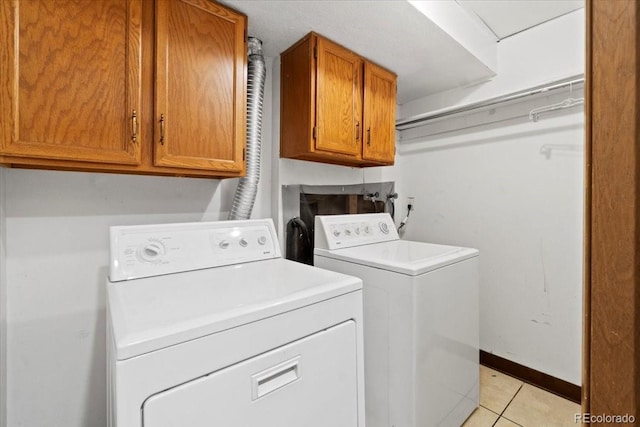 2306 S Troy St Unit A, Aurora, CO 80014 - laundry area with light tile patterned floors, baseboards, cabinet space, and independent washer and dryer
