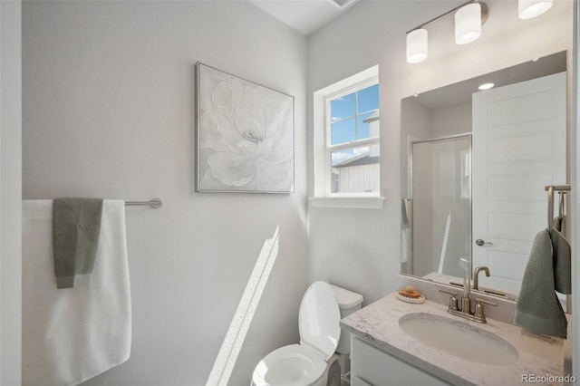 bathroom with toilet, an enclosed shower, and vanity