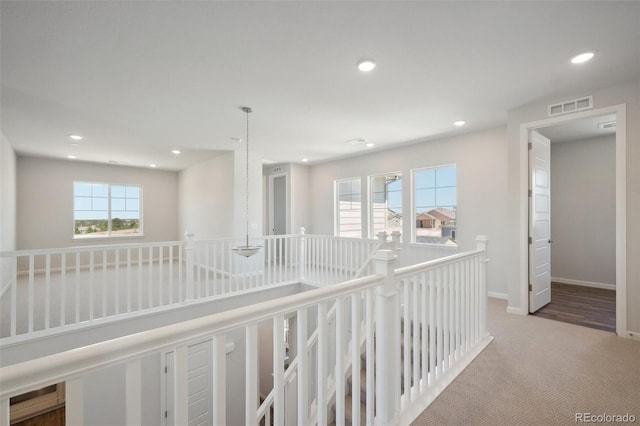 corridor with visible vents, carpet, baseboards, an upstairs landing, and recessed lighting