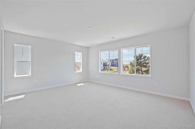 spare room featuring visible vents, baseboards, and carpet floors