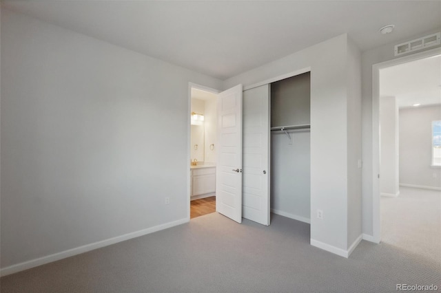 unfurnished bedroom featuring a closet, visible vents, baseboards, and carpet floors