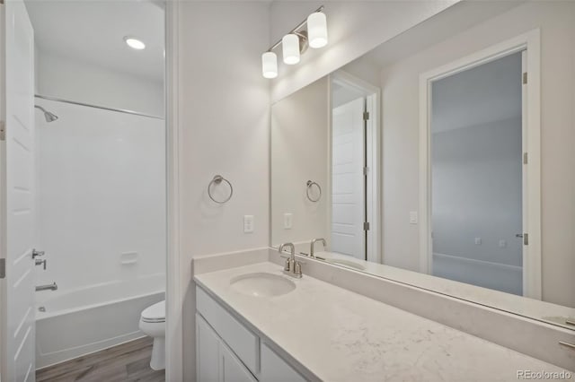 bathroom featuring tub / shower combination, toilet, vanity, and wood finished floors