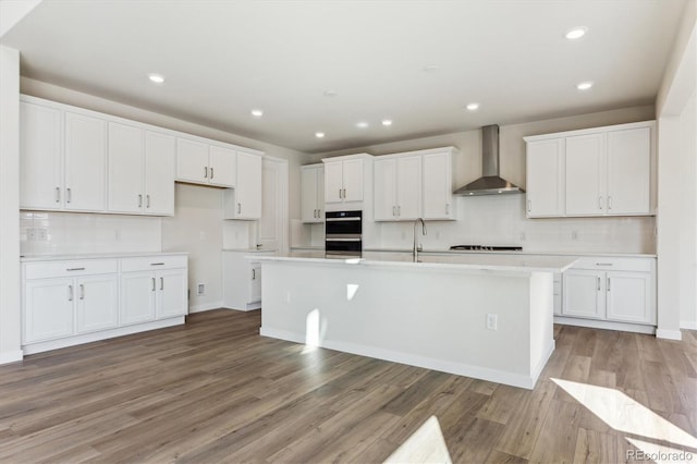 13900 Hanging Lake St, Parker, CO 80138 - kitchen featuring wall chimney exhaust hood, light wood-style flooring, and white cabinets
