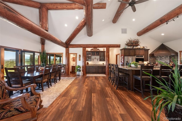 dining room with beamed ceiling, dark hardwood / wood-style floors, ceiling fan, and high vaulted ceiling