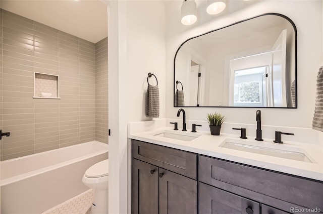 full bathroom with vanity, tiled shower / bath, and toilet