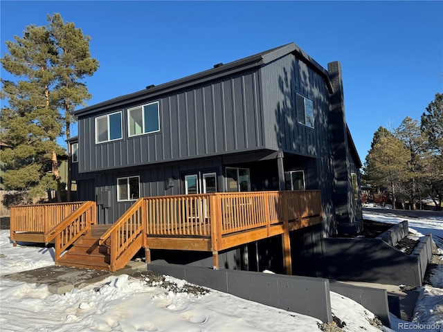 snow covered house with a wooden deck