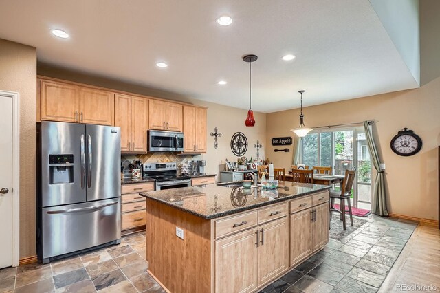 15056 Fillmore Way, Thornton, CO 80602 - kitchen featuring stainless steel appliances, dark stone countertops, stone tile floors, tasteful backsplash, and an island with sink
