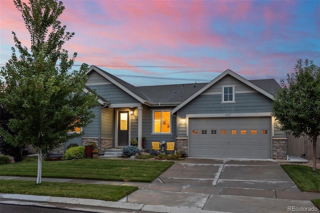 craftsman inspired home featuring a garage and a yard