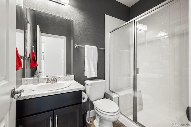 bathroom with vanity, toilet, and a shower with door