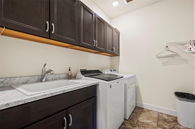 laundry area with cabinets, separate washer and dryer, and sink