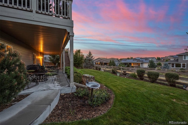 yard at dusk featuring a patio