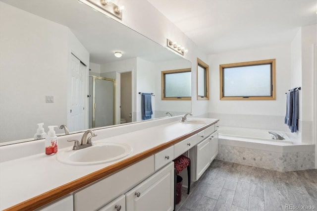 5282 Devon Ave, Castle Rock, CO 80104 - bathroom featuring a stall shower, double vanity, a garden tub, and wood finished floors