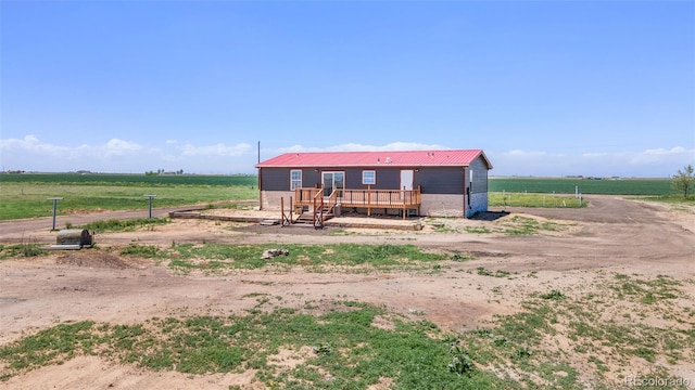 view of front of house featuring a deck, a view of countryside, and metal roof