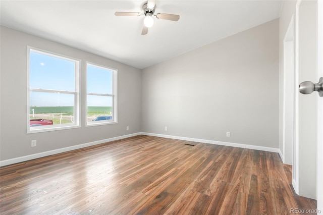 spare room featuring dark wood finished floors, baseboards, and a ceiling fan