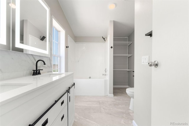 bathroom featuring double vanity, tub / shower combination, toilet, and marble finish floors