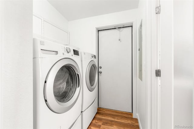 washroom with washer and clothes dryer and light wood-style flooring