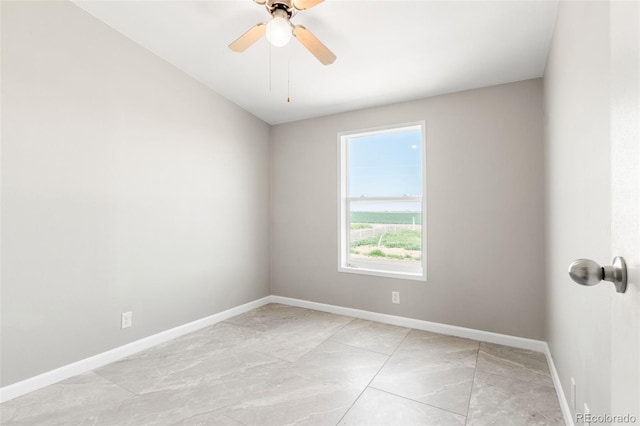 spare room with baseboards and ceiling fan