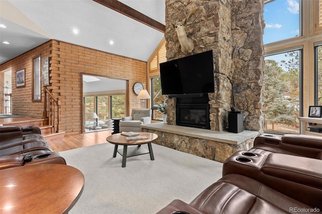 living room featuring hardwood / wood-style flooring, a fireplace, high vaulted ceiling, and beamed ceiling