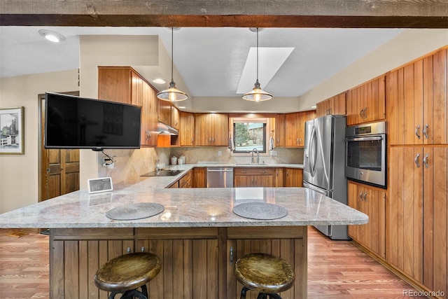 kitchen with a breakfast bar, hanging light fixtures, stainless steel appliances, tasteful backsplash, and kitchen peninsula